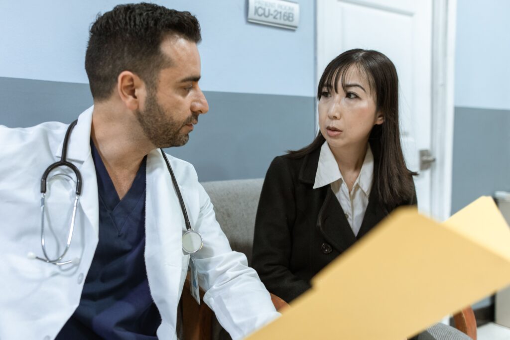 相談室で資料を見ながら話し合う医療者と相談者